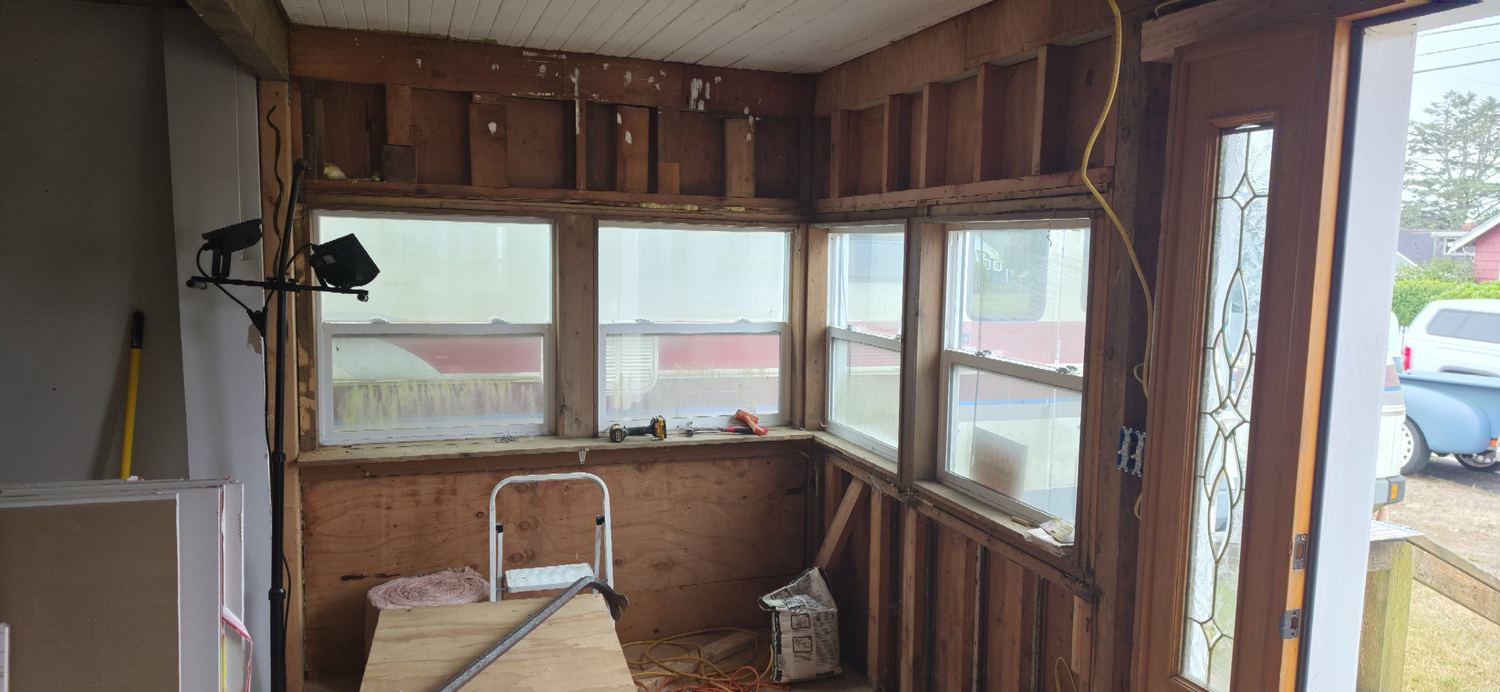 Corner of the porch with exposed framing and a step stool