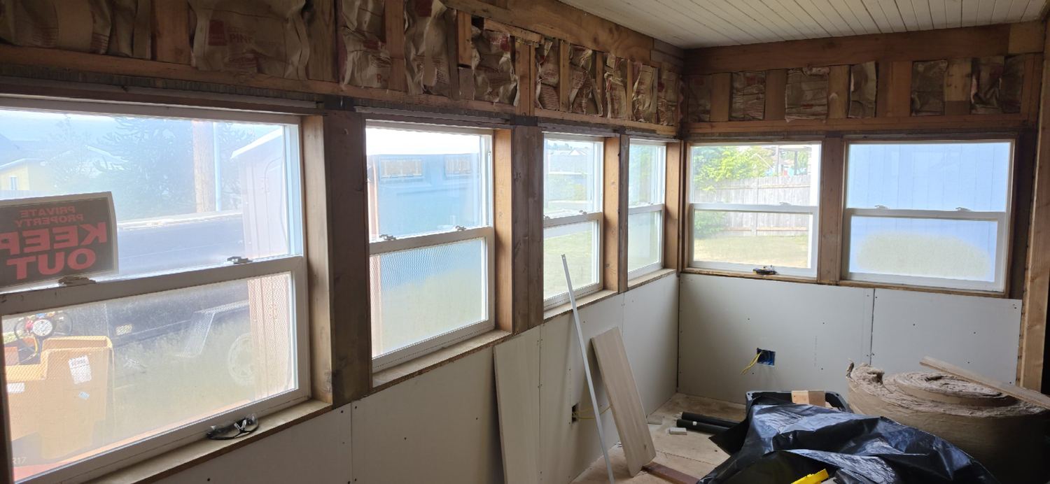 Lower walls drywalled under the row of windows, upper walls still open
